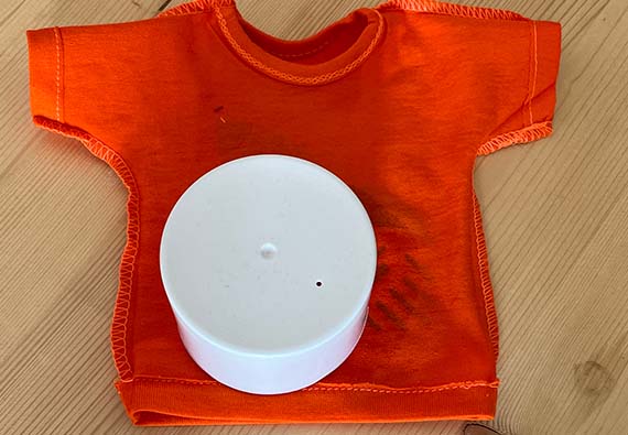 Hvit kork på oransje t-skjorte