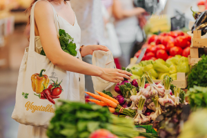 Dame som handler grønnsaker med handlenett på skulderen